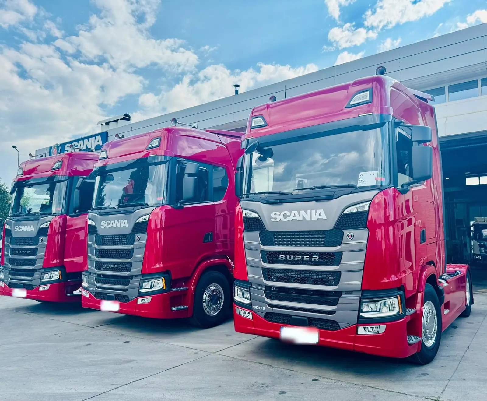 Drie rode Scania S-trucks voor een werkplaats